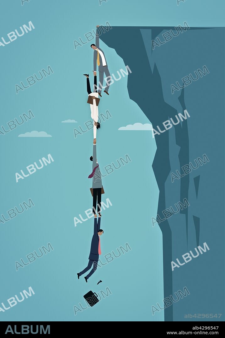 Business people dangling over edge of cliff holding on to each other in human chain.