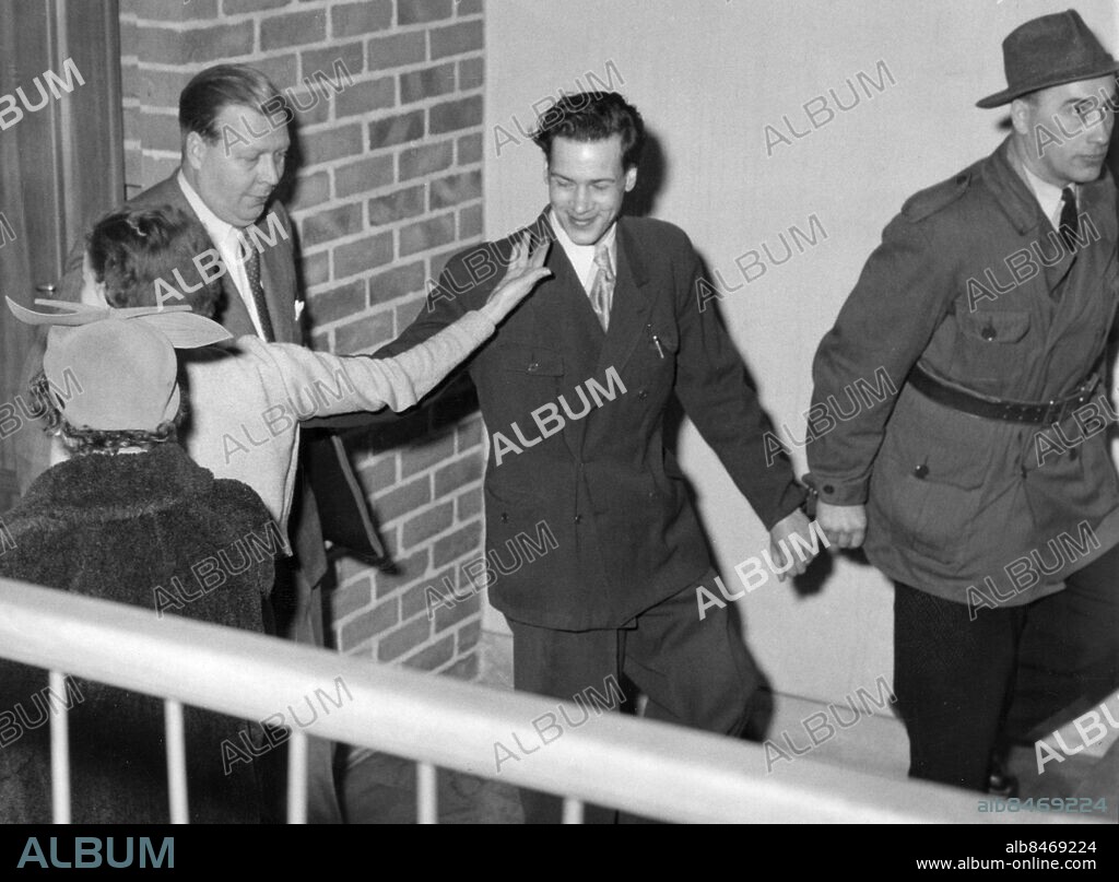 STOCKHOLM 1954-11-30. Rolf Johansson, alias "Tumba-Tarzan", förs till rätten fastlänkad till konstapel Rudolf Jonsson och förhandlingar inför Södertörns domsaga. Här hälsar han på hustrun Alice Johansson.. Foto: Bertil Stilling / EXP / TT / Kod: 40 . **AFTONBLADET OUT**.