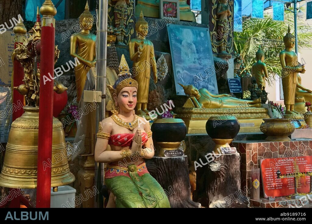 Thailand: A prayer shrine at Wat Ratchathiwat, Bangkok, with a female figure performing a traditional Thai wai (greeting).