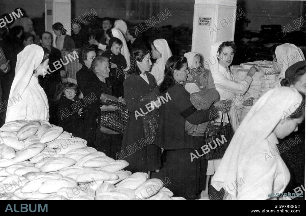 1956. Reparto de víveres A los Pobres, Presidido por la duquesa viuda de la Victoria, en el edificio central de la cruz Roja, en Madrid.