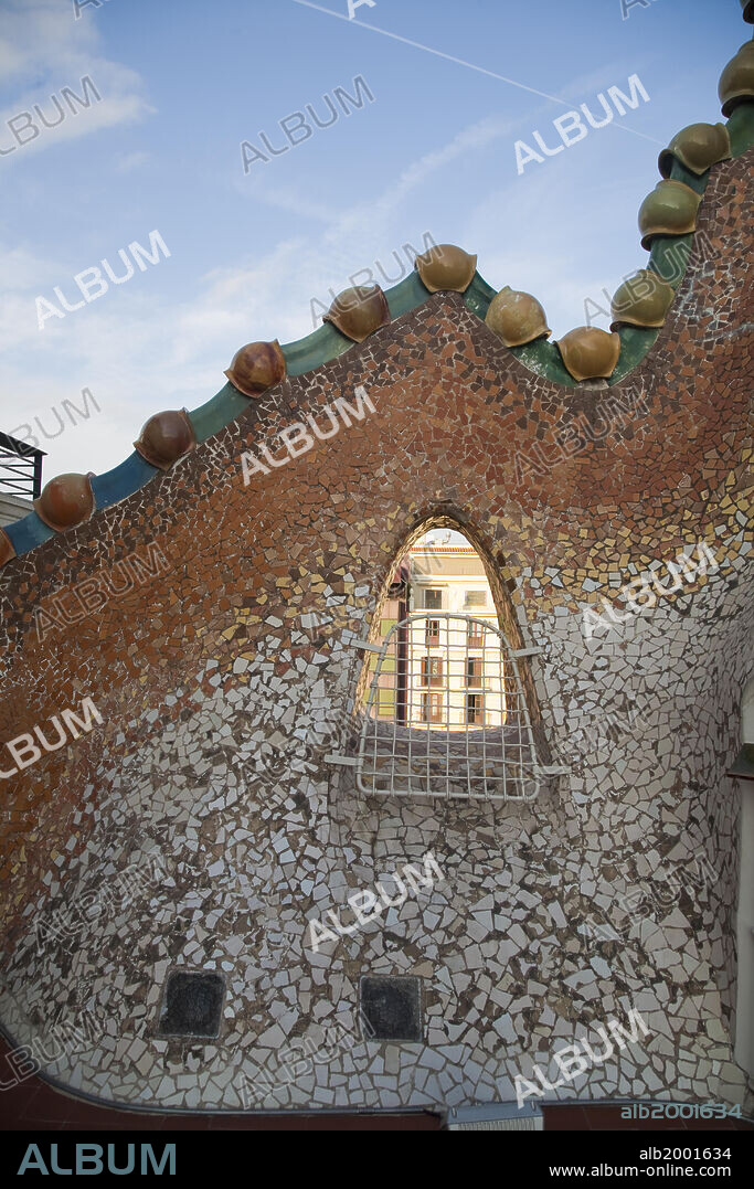 Casa Batllo was built in the year 1877 and remodeled by Antonio Gaudi in the years 1905-1907 for the Batllo family, living in the first floor. Because of the curved roof and skeletal organic quality, the local name for the building is House of Bones or House of the Dragon. A common theory is that the house represents the battle of Saint George with the dragon. The building is decorated in  Modernisme style, with a mosaic made of broken ceramic tiles in shades of orange, green and blue. The building was awarded as one of the three best buildings of the year 1906 by the Barcelona City Council; Batllo House is one of the seven works of Gaudi that were declared World Heritage sites by UNESCO in 1984. Along with Casa Ametllar and Casa Lleo-Morera, it makes up the three most important buildings in Barcelona's famous "Illa de la Discordia" ("Block of Discord") [formerly known as "Apple of Discord" (manzana de la Discordia)], noted for its unique modernist buildings.