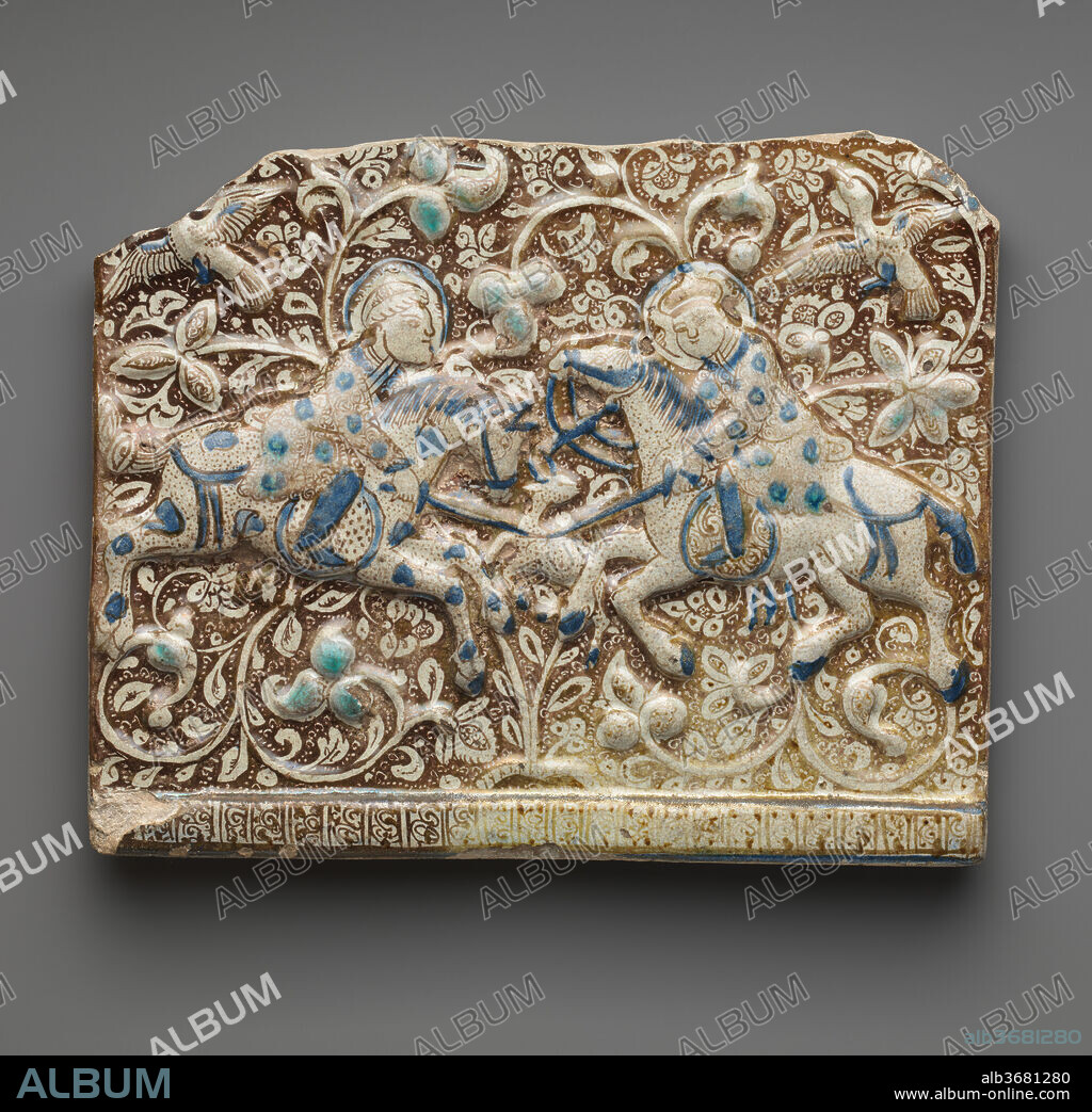 Frieze Tile. Dimensions: H. 10 3/4 in. (27.3 cm)
W. 13 1/4 in. (33.7 cm)
D. 1 1/8 in. (2.9 cm). Date: second half 13th century.
This frieze tile is molded in low relief and painted in luster over an opaque white ground with accents of turquoise and cobalt blue. The background presents a lush landscape of vegetal motifs and birds in flight, while in the foreground two horsemen stab a deer with their swords. The figures wear luxurious clothes, and the artist has taken care to depict different textile patterns on each. Luster tiles of similar quality, color scheme, and motifs decorated the palace at Takht-i Sulaiman, an important Ilkhanid imperial residence.