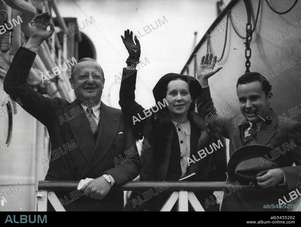 Famous Pioneer Of American Film Industry Arrives In England.
Mr. Jesse Lasky, with his wife and son waving a greeting from the Empress of Australia on arrival at Southampton from Quebec today, Sept. 13.
Mr. Jesse Lasky, one of the pioneers of the American film industry, who has joined Miss Mary Pickford, to form the Pickford-Lasky Film Productions Co., arrived in England on board the Empress of Australia today, Sept. 13. He is here to make arrangements for English productions for the new company, and in his first visit to England for five years. September 13, 1935. (Photo by Associated Press Photo).