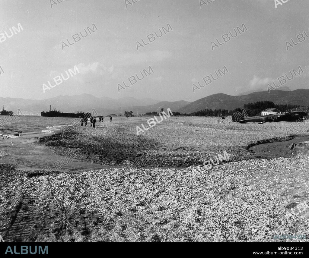 WW2: Beach scene at "Red Beach" near Salerno, Italy. Notice the wrecked American P-38 airplane at right. 9th Sept. 1943.