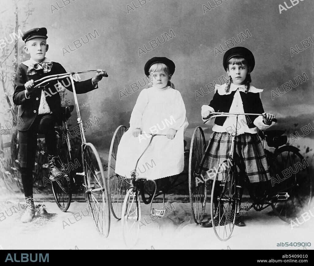 Children posed with bicycle and tricycles. A bicycle, also called a cycle or bike, is a human-powered, pedal-driven, single-track vehicle, having two wheels attached to a frame, one behind the other. A tricycle, often abbreviated to trike, is a human-powered (or gravity-powered) three-wheeled vehicle. Detroit Publishing Company, circa 1910-20 (cropped and cleaned).