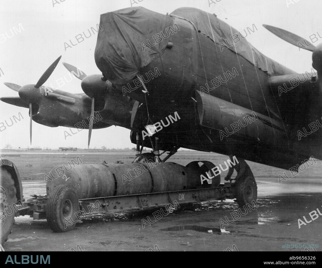 R.A.F. is 12,000 Lb, Bomb -- Preparing to load a 12,000 lb. bomb on to a waiting Lancaster.R.A.F. Bomber Command has been dropping an ever bigger bomb on industrial targets in occupied France and Germany. The new 12,000 pounder has been used with devastating effects on factories working for the enemy. March 11, 1944. (Photo by British Official Photograph).