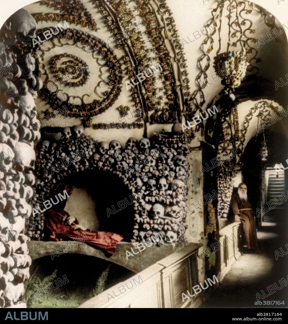 Stereograph shows corridor in the Cappuccini Catacombs, Rome, Italy, 1897. The Capuchin Crypt is a small space comprising several tiny chapels located beneath the church of Santa Maria della Concezione dei Cappuccini on the Via Veneto near Piazza Barberini in Rome, Italy. It contains the skeletal remains of 3,700 bodies believed to be Capuchin friars buried by their order. The Catholic order insists that the display is not meant to be macabre, but a silent reminder of the swift passage of life on Earth and our own mortality. When the monks arrived at the church in 1631, moving from the old monastery, they brought 300 cartloads of deceased friars. Fr. Michael of Bergamo oversaw the arrangement of the bones in the burial crypt. The soil in the crypt was brought from Jerusalem, by order of Pope Urban VIII. As monks died during the lifetime of the crypt, the longest-buried monk was exhumed to make room for the newly-deceased who was buried without a coffin, and the newly-reclaimed bones were added to the decorative motifs. This image has been color enhanced.