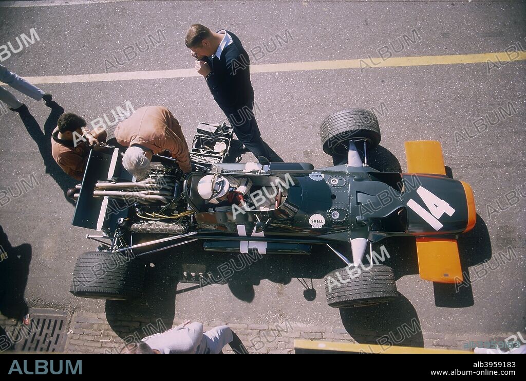 John Surtees in his BRM at the British Grand Prix, Silverstone, Northamptonshire, 1969. Mechanics work on the car while Surtees sits in the cockpit. John Surtees came to car racing in 1959 after a highly successful motorcycle racing career. He drove in Formula 1 from 1960 to 1972, winning 6 races and becoming World Champion in 1964 with Ferrari. Surtees drove for Honda in the 1967 and 1968 seasons. He formed his own team in 1970, which ceased competing in 1978. He spent only one season with BRM, the unreliable car ailing to finish in half the races, including this one.