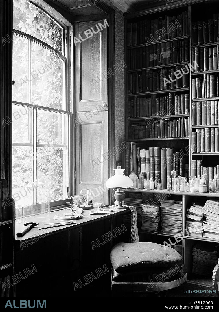 Charles Darwin's study showing a bench in the window with Darwin's microscope. Down House in Downe, Kent, is where Charles Darwin worked for 40 years and died in 1882. This photograph is from 1932. Darwin (1809-1882) was an English naturalist and geologist. He established that all species of life have descended over time from common ancestors, and in a joint publication with Alfred Russel Wallace introduced his scientific theory that this branching pattern of evolution resulted from a process that he called natural selection, in which the struggle for existence has a similar effect to the artificial selection involved in selective breeding.