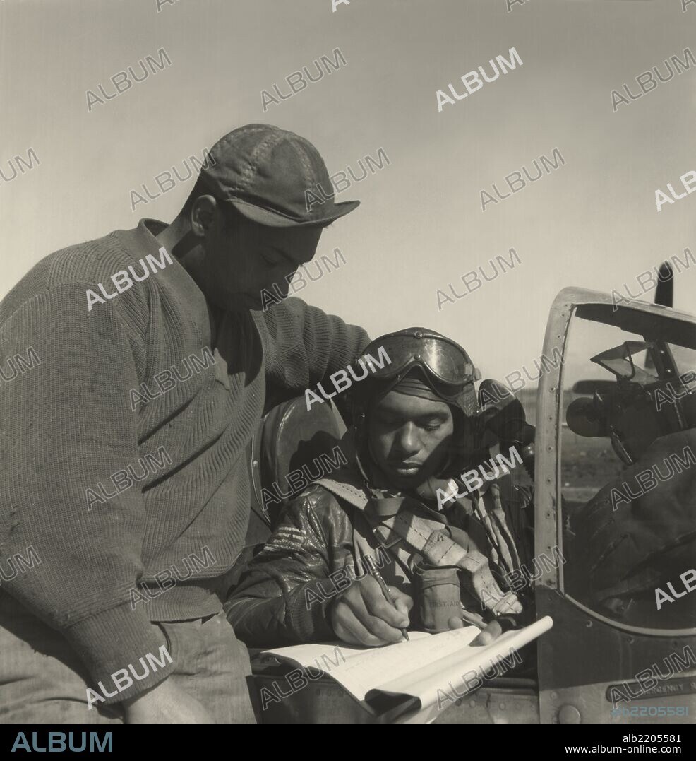 Photograph shows a pilot from the 332nd Fighter Group signing the Form One Book, indicating any discrepancies of aircraft, prior to take off.