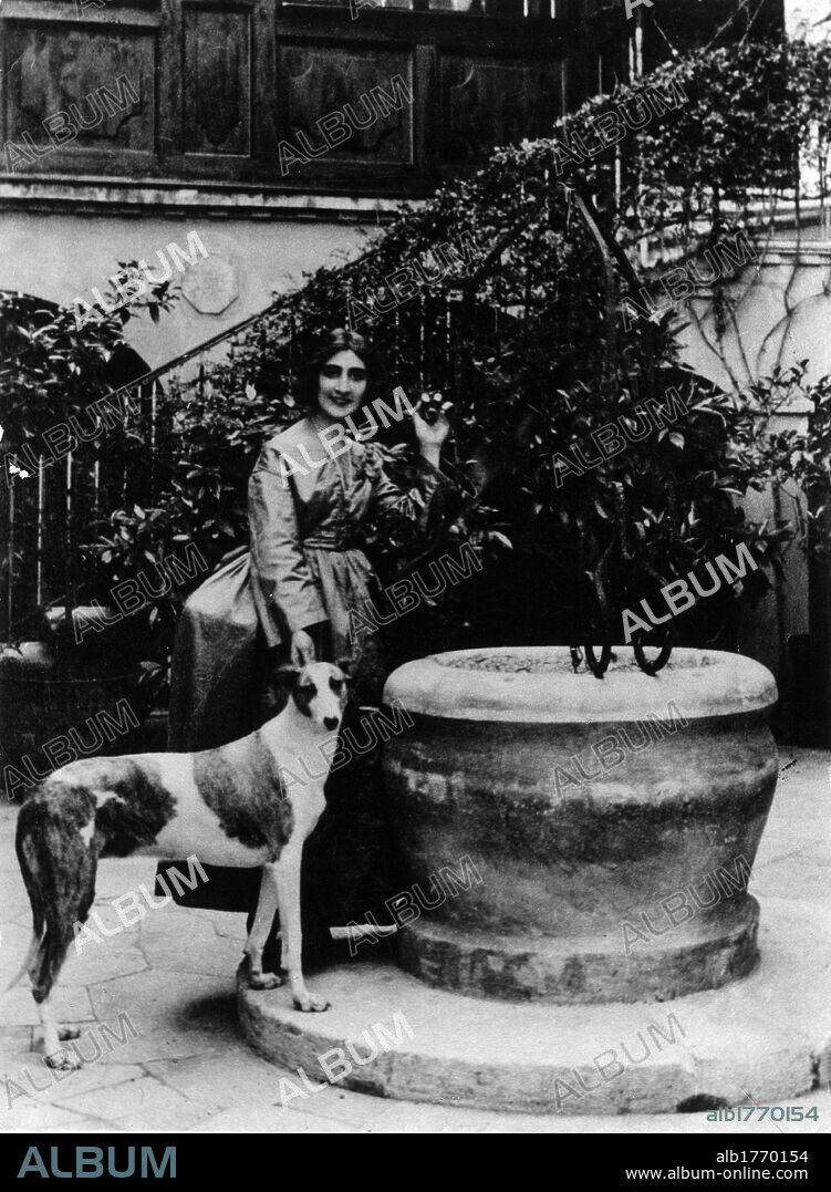 Portrait of Luisa Baccara. Italian pianist Luisa Baccara, Gabriele D'Annunzio's mistress, next to a well with dog on a leash. 1920S.