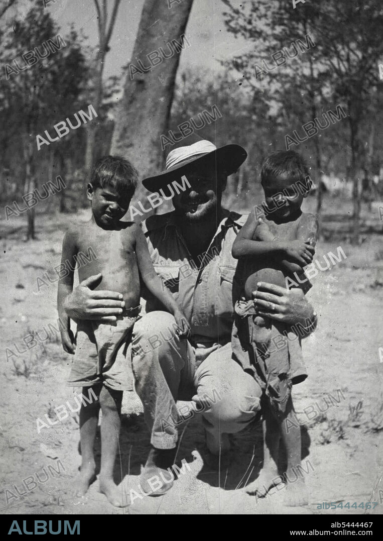 Patrol Officer Sydney Kyle little shown with two piccaninnies of the Port Keats Mission district, Northern Territory, Australia. January 13, 1947.