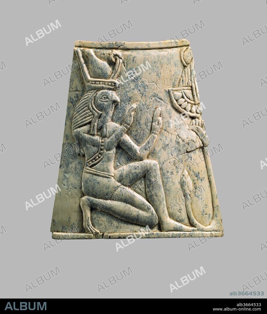 Plaque with falcon-headed Re wearing crown of Upper and Lower Egypt. Culture: Assyrian. Dimensions: H. 2 13/16 x W. 1 5/8 x D. 2 7/16 in. (7.1 x 4.1 x 6.2 cm). Date: ca. 8th-7th century B.C..
This curved, trapezoidal ivory plaque was found in a storage room in Fort Shalmaneser, a royal building at Nimrud that was used to store booty and tribute collected by the Assyrians while on military campaign. It depicts a figure with the head of a falcon kneeling with elbows bent and palms held outwards, facing a stylized tree to the right. The figure wears a type of Egyptian headdress called a lappet wig, topped by a version of the Egyptian double crown which has a curled element added at the front. He is dressed in a belted garment with short skirt and loose, short sleeves, decorated with a beaded border, and is barefoot. The stylized tree is made up of a vertical trunk topped by a palmette and a curving branch rising from the root, topped by a bud; presumably the other half of the tree would have been symmetrical, and was depicted on the adjoining plaque to the right when this plaque was still in its original setting. Atop the palmette is an element combining a wide Egyptian necklace called a broad collar and an isolated head, visible only in the edge of the headdress represented by parallel vertical lines and part of a sun disc. Like the tree, this element would have been completed on the adjoining plaque, which is now missing, but enough remains to suggest that it was an aegis, an image of the head and shoulders of a deity. An ivory aegis of a feline goddess from Nimrud, in the collection of the Metropolitan Museum, gives an idea of how the complete element might have looked. Carved ivory pieces such as this were widely used in the production of elite furniture and luxury objects during the early first millennium B.C., and could be overlaid with gold foil or inlaid to create a dazzling effect of gleaming surfaces and bright colors. This piece is one of many elaborately carved ivories with motifs adapted from Egyptian art that have been attributed to Phoenician workshops, as Phoenician art shows strong Egyptian influence. It was found with many other small curved trapezoidal plaques, suggesting that these pieces were originally fitted together to create ring-shaped objects that were wider at the bottom than the top. If equipped with bases and lids, these plaques could have been used as boxes, or alternatively they could have served as stands for bowls or round-bottomed goblets. 
Built by the Assyrian king Ashurnasirpal II, the palaces and storerooms of Nimrud housed thousands of pieces of carved ivory. Most of the ivories served as furniture inlays or small precious objects such as boxes. While some of them were carved in the same style as the large Assyrian reliefs lining the walls of the Northwest Palace, the majority of the ivories display images and styles related to the arts of North Syria and the Phoenician city-states. Phoenician style ivories are distinguished by their use of imagery related to Egyptian art, such as sphinxes and figures wearing pharaonic crowns, and the use of elaborate carving techniques such as openwork and colored glass inlay. North Syrian style ivories tend to depict stockier figures in more dynamic compositions, carved as solid plaques with fewer added decorative elements. However, some pieces do not fit easily into any of these three styles. Most of the ivories were probably collected by the Assyrian kings as tribute from vassal states, and as booty from conquered enemies, while some may have been manufactured in workshops at Nimrud. The ivory tusks that provided the raw material for these objects were almost certainly from African elephants, imported from lands south of Egypt, although elephants did inhabit several river valleys in Syria until they were hunted to extinction by the end of the eighth century B.C.