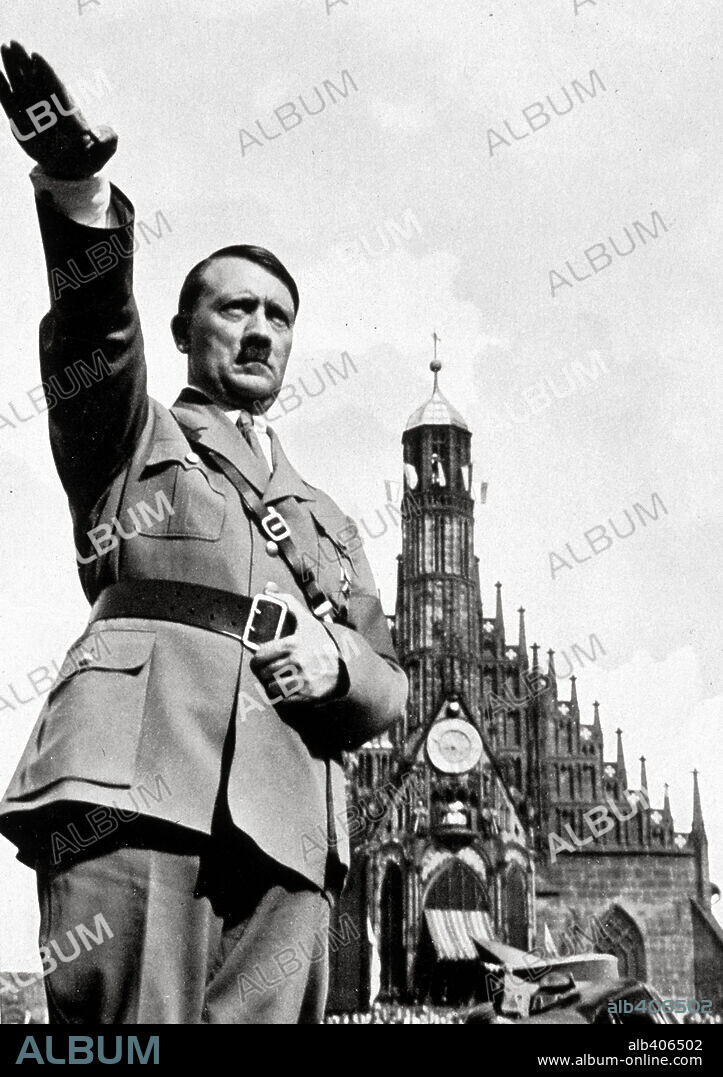 Adolf Hitler salutes from his car while on parade. Nuremberg, 1934.