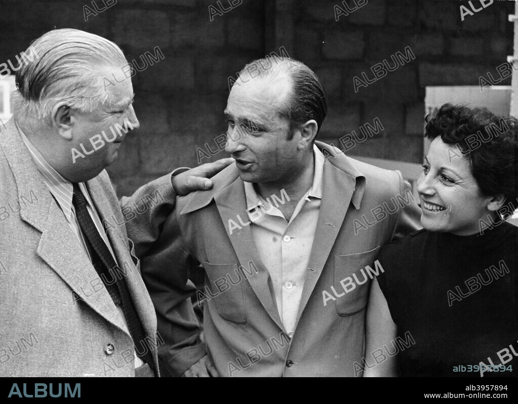 Alfred Neubauer with Juan Manuel Fangio and his wife, c1954-c1955. Neubauer is congratulating Fangio on successful practice in Rheims, France. Neubauer was the highly successful manager of the Mercedes-Benz motor racing team, for whom Fangio drove in the 1954 and 1955 Grand Prix seasons. In his Formula 1 career between 1950 and 1958, Fangio won a then record 24 Grands Prix, 8 of them while with Mercedes, and won the World Drivers' Championship in 1951, 1954, 1955, 1956 and 1957, a record which remains unequalled. The most remarkable aspect of Fangio's record is that these successes came from a career which only lasted for 51 races.