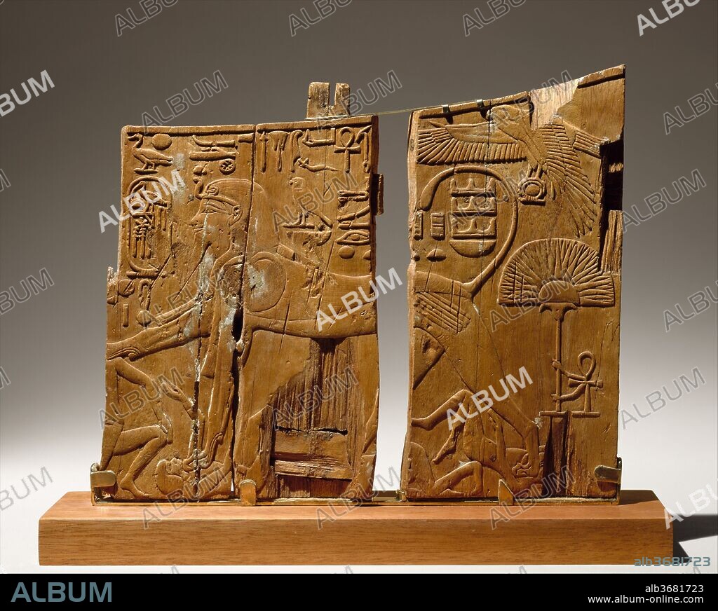 Arm Panel From a Ceremonial Chair of Thutmose IV. Dimensions: H. 25.1 cm (9 7/8 in). Dynasty: Dynasty 18. Reign: reign of Thutmose IV. Date: ca. 1400-1390 B.C..
In 1903 Theodore M. Davis discovered a tomb in the Valley of the Kings that belonged to Tuthmose IV, whose throne name was Menkheperure. The fragmentary remains of the king's funerary equipment included this arm panel from a throne. A second arm panel from the same throne is now in the Museum of Fine Arts, Boston.  The scenes on the panels suggest that the throne was used either for the king's coronation, or possibly for his thirty-year jubilee, the Sed festival, or Heb-Sed. 
The panel in the Metropolitan Museum is from the left arm of the throne.  Traces of glue on the surface suggest that the beautifully carved low relief, with its exquisitely executed details, was once covered with gold foil.  On one side, the king is shown as a sphinx subduing the enemies of Egypt. The front edge of the panel is missing, but the text before the king's face probably read: "Lord of the Two Lands, Menkheperure, son of Re, Tuthmose, [given] life like Re."  The falcon at the upper right represents the god Horus who is identified as "the Behedite, the great god, with dappled plumage, giving life and dominion."  The text above the sphinx's back reads: "Horus, the lord of might and action, trampling all foreign lands."
On the other side, the panel depicts the enthroned Thutmose, described as "the young god, Menkheperure," wearing the red crown of Lower Egypt. In front of him is the lion-headed goddess Weret, whose name is written above her head.  Behind the king is the ibis-headed god Thoth "Lord of Hermopolis, giving all life and dominion."  Thoth says, "I have brought you millions of years of life and dominion united with eternity."  Behind the throne is the phrase "All life and dominion around him [like] Re.".