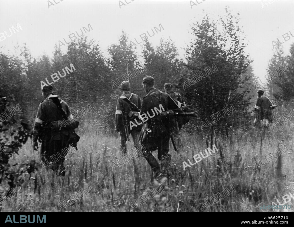 The Nazi Propaganda! on the back of the image reads: "A gang was destroyed. In the forest in the back of the image in the middle section of the front, a search was carried out to catch strolling gangs. It was only a few days ago that several villages were alarmed. Spying troops, which went deep into the woods reported that a barn on a great clearing served as a shelter for the gang. From here, they moved out to disturb the villages. The task was to annihilate the gang, particularly because some of the gang members wore parts of German uniforms. Around midnight, the supplies  were given and in the morning the infantry issued an attack after artillery preparation. Image from the Eastern Front/Russia, published on 1 October 1942. Since the summer of 1942, the German were not allowed to use the term "partisans" anymore for psychological reasons. Instead, terms like "gangs", "bandits", and "gang combat" were employed. The attack on the Soviet Union by the German Reich was agreed on in July 1940 and prepared as the "Operation Barbarossa" since December 1940. On 22 June 1941, the invasion by the German Wehrmacht started. Photo: Fotoarchiv für Zeitgeschichte/Archiv. 01/10/1942