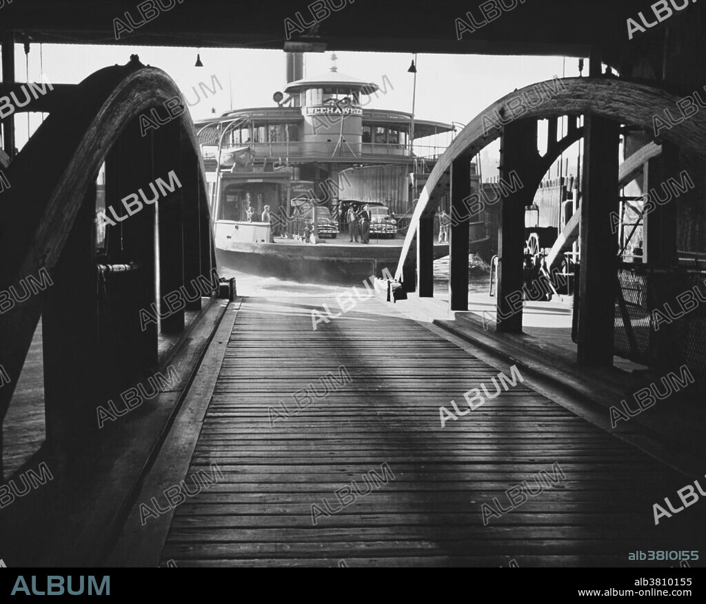 The New Jersey Ferry arriving at its 42nd St. Manhattan pier, with commuters and cars on board, 1952.