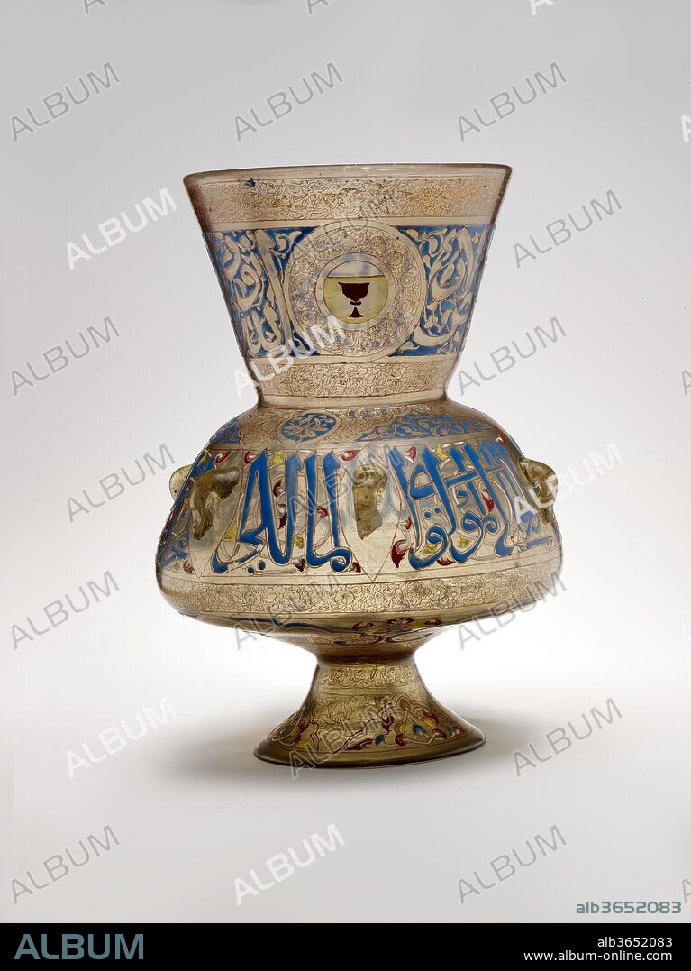 Mosque Lamp of Amir Qawsun. Dimensions: H. 14 1/8 in. (35.9 cm)
Max. diam. 10 1/16 in. (25.6 cm)
Diam. with handles 10 5/16 in. (26.2 cm). Maker: 'Ali ibn Muhammad al-Barmaki ?. Date: ca. 1329-35.
Large glass lamps of this type were commissioned by sultans and members of their court for mosques, <i>madrasa</i>s (Qur'anic schools), tombs, hospices, and other public buildings in fourteenth-century Mamluk Cairo. This example bears the name of its patron, Qawsun (d. 1342), amir of the Sultan al-Nasir Muhammad ibn Qalaun (r. 1293-1341 with brief interruptions), and was probably intended for one of his two architectural commissions in Cairo--a mosque or a tomb-hospice complex.