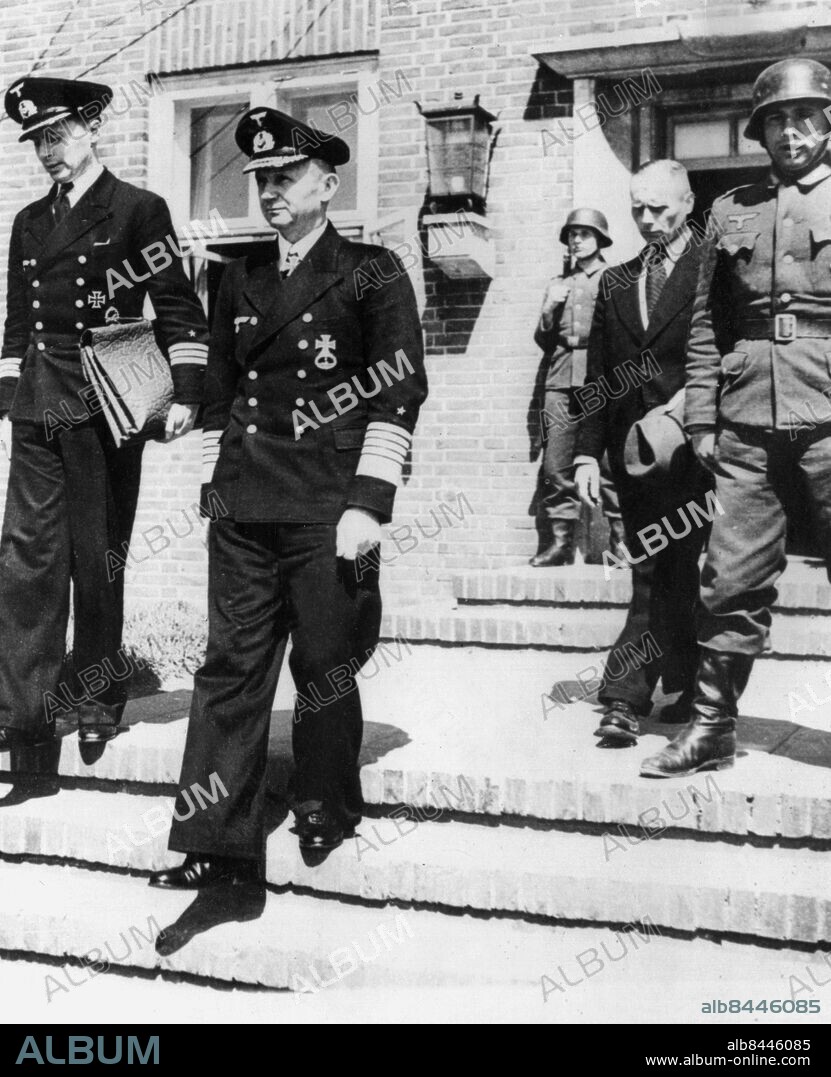 Orig. bildtext... THE NEW GERMAN 'FUEHRER' LEAVES HEADQUARTERS- Germany. Admiral Karl Doenitz (second from left) self-appointed head of the German state is shown leaving the headquarters of the surrendered German High Command at Flensburg, Germany accompanied by an aide. Not. Dönitz Anm. K Dönitz, 1891-1980, tysk militär, chef för tyska ubåtsvapnet 1935-1943, storamiral, Nazitysklands president och sista ledare för Tredje riket 1945. Militärer Amiraler Järnkorset Galoner Högkvarter Tyska örnen Portföljer Presidenter Hjälmar Efterkrigstiden CD499 persons: KARL DÖNITZ sites: TYSKLAND;FLENSBURG.