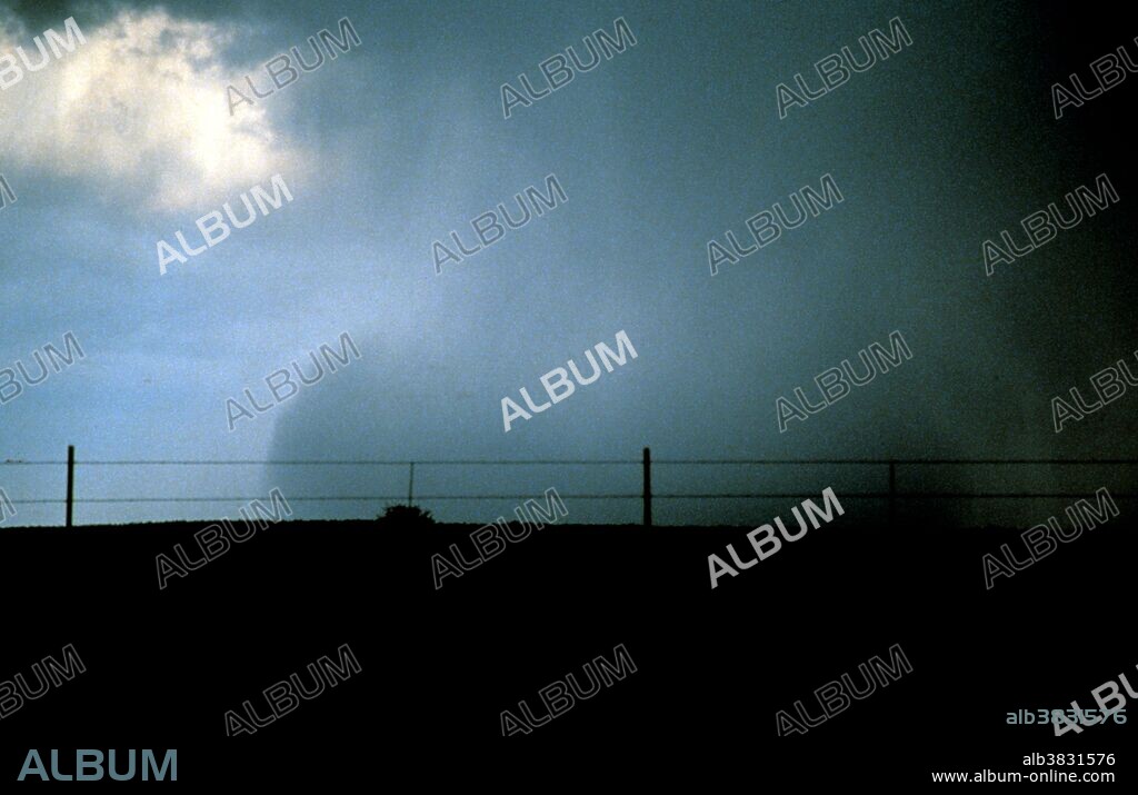 Wet microburst. Photo #4. Circa 1980. No location given. Wet microbursts are downbursts accompanied by significant precipitation at the surface which are warmer than their environment. These downbursts rely more on the drag of precipitation for downward acceleration of parcels than negative buoyancy which tend to drive "dry" microbursts. As a result, higher mixing ratios are necessary for these downbursts to form. Melting of ice, particularly hail, appears to play an important role in downburst formation. These factors, among others, make forecasting wet microbursts a difficult task.