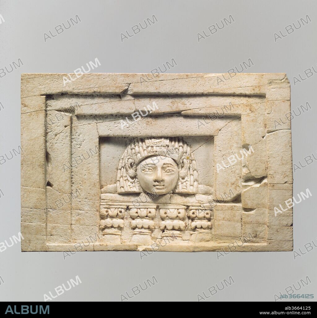 Furniture plaque carved in relief with a "woman at the window". Culture: Assyrian. Dimensions: 3.27 x 4.72 in. (8.31 x 11.99 cm). Date: ca. 9th-8th century B.C..
During the early first millennium B.C., ivory carving was one of the major luxury arts that flourished throughout the ancient Near East. Elephant tusks were carved into small decorative objects such as cosmetic boxes and plaques used to adorn wooden furniture. Gold foil, paint, and semiprecious stone and glass inlay embellishments enlivened these magnificent works of art. Based on certain stylistic, formal, and technical characteristics also visible in other media, scholars have distinguished several coherent style groups of ivory carving that belong to different regional traditions including Assyrian, Phoenician, North Syrian and South Syrian (the latter also known as Intermediate).
Several ivories in the Metropolitan Museum's collection are from the Aramaean town of Arslan Tash, ancient Hadatu, in northern Syria just east of the Euphrates River, close to the modern Turkish border. French archaeological excavations at the site in 1928 revealed city walls and gates in addition to a palace and temple that were built when the Neo-Assyrian king Tiglath-Pileser III (744-721 B.C.) turned the town into a provincial capital and military outpost. During the excavations, over one hundred ivory furniture inlays that can be attributed to the South Syrian and Phoenician styles were found in a building near the palace. One piece bears a dedicatory inscription in Aramaic to King Hazael, mentioned in the Bible, who ruled Damascus during the second half of the 9th century (ca. 843-806 B.C.), suggesting that this collection of ivory furniture inlays could have been taken by the Assyrian state as tribute or booty from Damascus. The Arslan Tash ivories share an amalgamation of Egyptianizing motifs typical of the Phoenician style and forms characteristic of North Syrian art that may indicate a South Syrian or Damascene origin of this group. Today, these ivories are housed in museums in Paris, Aleppo, Jerusalem, Karlsruhe, and Hamburg, as well as The Metropolitan Museum of Art.
Depicted on this rectangular plaque is one of several variations of the "woman at the window" theme found at Arslan Tash and other sites in Mesopotamia and the Levant. The head of a female wearing a diadem and loop earrings is surrounded on three sides by a frame with two recessed bands. Below, four columns terminating in volute capitals support a balustrade. While such imagery appears to have a Phoenician derivation, this plaque can be attributed to the South Syrian style, expressed by a combination of North Syrian and Phoenician elements. Aspects of the North Syrian tradition include the woman's large, round face, large ears, small mouth and receding chin. Drawn from the Phoenician style is the short, Egyptian-style wig. Two mortises cut into the roughened back of the plaque indicate that it was probably made to receive pegs for insertion into a piece of furniture. There is a West Semitic letter inscribed into the right side of the upper edge, probably as a guide for the assembly of the piece of furniture into which it originally belonged. There is no conclusive interpretation of whom these plaques were meant to represent; some scholars associate them with the Levantine goddess Astarte.