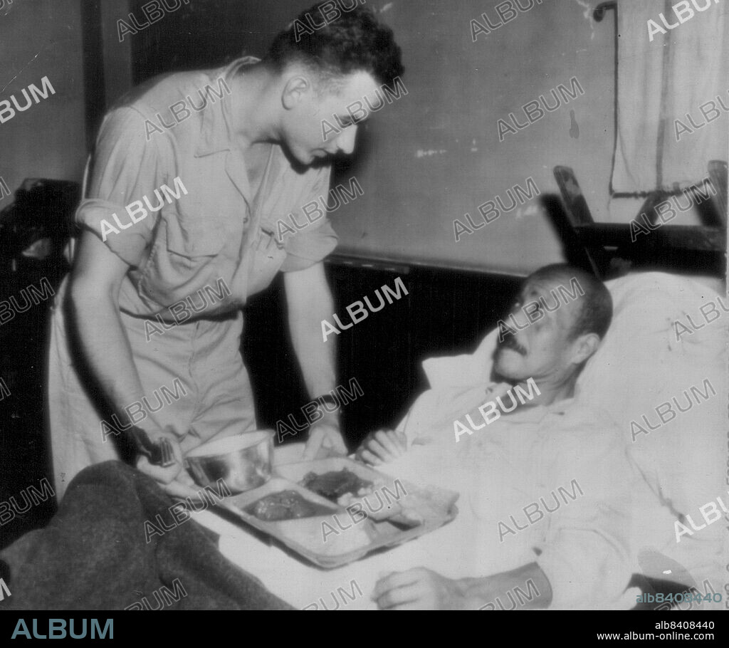 Former Premier of Japan Recovering -- Former premier of Japan, general Hideki Tojo, receives a tray of GI food at the U.S. 43rd field hospital, Yokohama, where he is recovering from self-in-flicted bullet wound suffered in his attempted suicide Sept. 11, 1945. Corp Edwin J. Podosek, hospital orderly of Chicago, Ill., serves the meal. October 16, 1945. (Photo by AP Wirephoto).