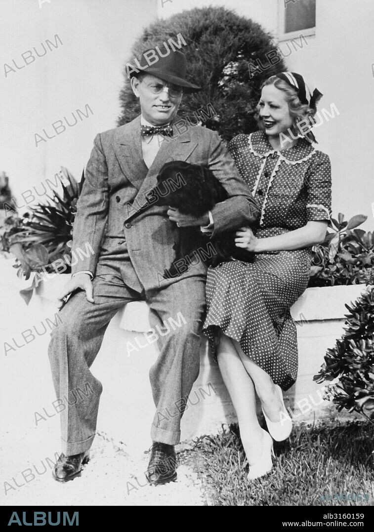 Miami Beach, Florida: November 18, 1935 Writer Damon Runyon with his wife and dog, 'Honey' outside their winter home in Florida.
