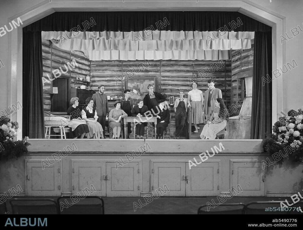 JOHN LAING PLC. Goodwyn Hall, Mill Hill, Barnet, London, 21/10/1961. Members of the Dramatic Section of the Laing Sports Club on stage at Goodwyn Hall, performing their take on the play 'Johnny Belinda' by Elmer Harris. The Sports Club Dramatic Section performed the play 'Johnny Belinda' on the 19th, 20th and 21st October 1961 at Goodwyn Hall, Mill Hill. The play is set in the extreme north of Canada and tells the story of a young girl who is deaf. At the door donations raised a total of £8 and 10s for the Royal Association in Aid of the Deaf and Dumb. This image was published in December 1961 in Laing's monthly newsletter 'Team Spirit'. Cast members in the image from left to right are: Valerie Werhle, Sylvia Brereton, Mike Gotch, Kathy Shuttleworth, Dick Murphy, Stuart Jameson, David Morgan, Joyce Moores, Jimmy Brownlee, Norma Young, Jack Hudson and Mair Davies.