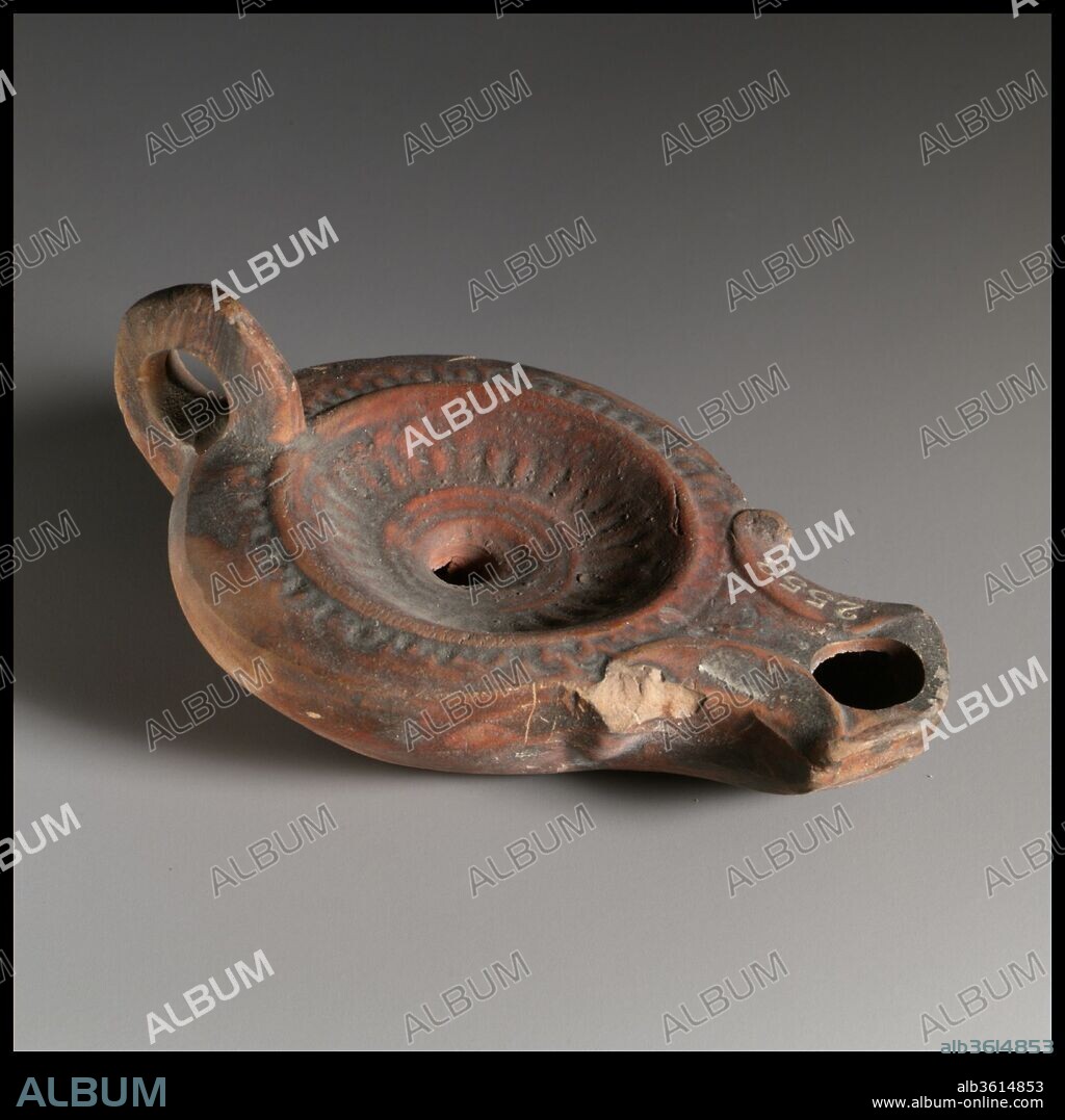 Terracotta oil lamp. Culture: Roman. Dimensions: Overall: 1 5/8 x 3 7/8 in. (4.1 x 9.8 cm). Date: 1st century B.C.-1st century A.D..
Loeschcke Type 1A. Mold-made, with ring handle. Discus; a pattern of radiating lines outside a central band of three raised concentric circles, and a raised outer edge; single filling hole at center. On curving shoulder, a pattern of close-set ovules. Volutes flanking broad, angular nozzle, with large wick hole. Broad raised ring base, and a slightly uneven base, with an obscure impressed mark (planta pedis?) at center.
Intact.