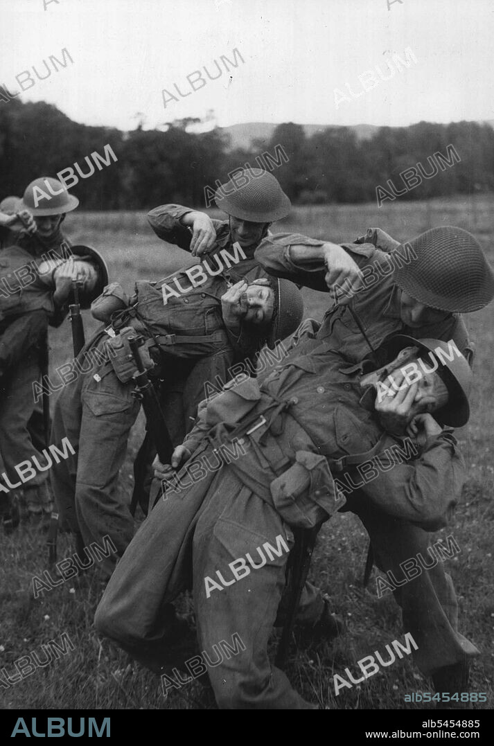 Scottish Home Guards' Commando Training - Unarmed Combat. Home Guards attacking a man from the rear and cutting his throat. Home Guards from Dundee and Angus recently spent a week with the Commandos, undergoing a special course at a Commando Depot. They went through all the latest methods of Commando training and when they left were well up in all the tricks of assault tactics. The course was a tough one and included "Battle Inoculation" use of the toggle rope map reading unarmed combat, field craft, route marches, boating, and a 36 hours exercise during which they bivouaced in the open Country for one night. August 03, 1943. (Photo by British Official Photograph).