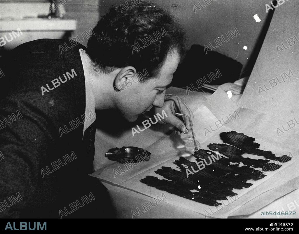 Oldest Bible Manuscript Is In Britain -- An assistant of the professor who brought the scroll to London, uses his glasses as a magnifying-glass to examine the 2,000-year-old script. An assistant examines a page from the Book of Isaiah, using his glasses to magnify the characters written there 2000 years ago. February 08, 1950. (Photo by Paul Popper Ltd.).