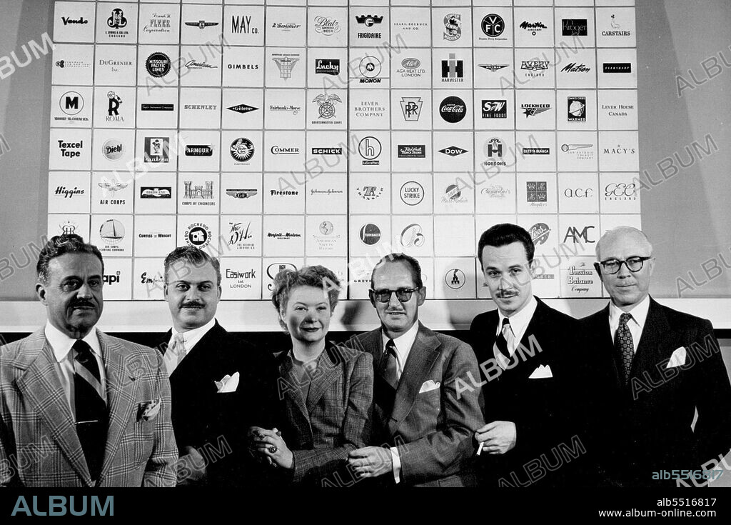 Biggest in business, six partners of Raymond Loewy Associates pose against mural of trade-marks of American. British Canadian product they designed.  They are Raymond Loewy, William T. Snaith, Jean Thomson Loewy Bienfait, A. Barnhart, Carl L. Otto, John B. Breen. April 11, 1949.