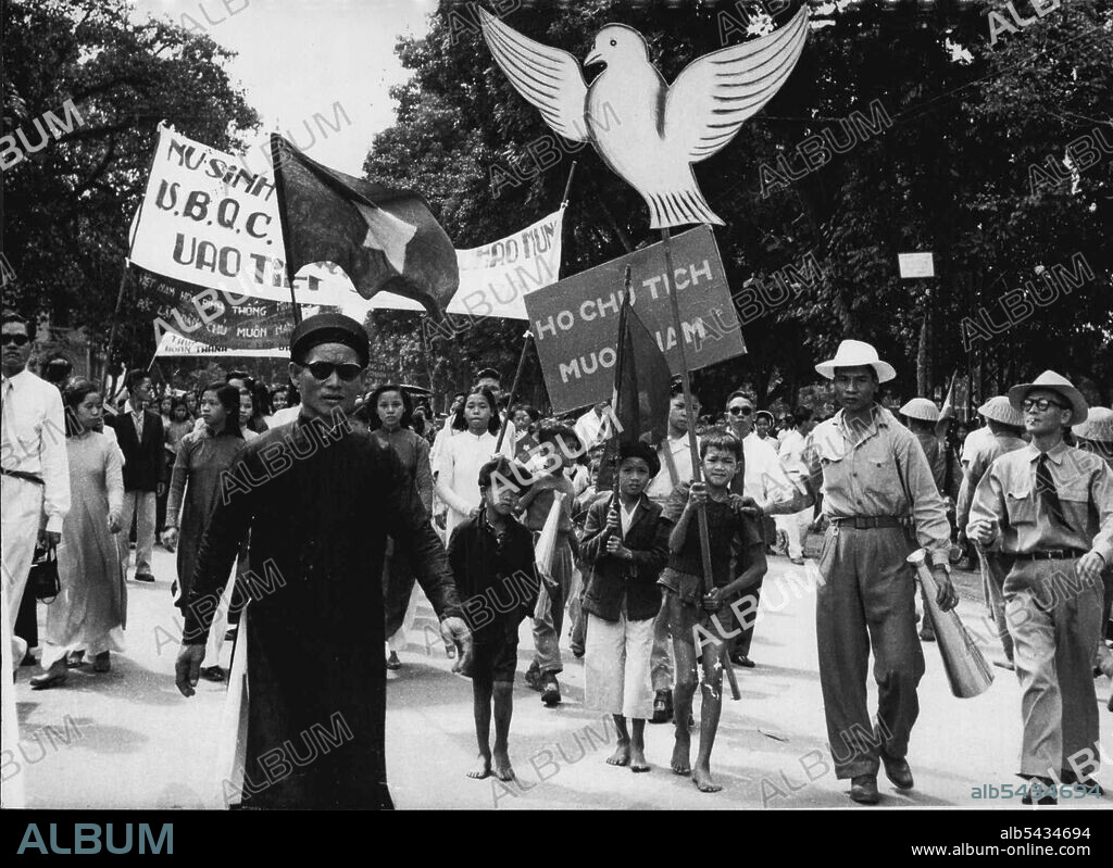 Vietnam March Into Hanoi -- Children with white peace Doves and slogans follow troops into Hanoi. More than 5,000 Vietminh staged a victory parade in Hanoi October 9. As they took over the city under the terms of the Geneva agreement. Cheering flag-waving civilians thronged the streets as the troops arrived. October 18, 1954. (Photo by Associated Press Photo).