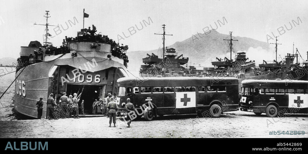 Busses For Communist Prisoners of War -- One bus is already full and ready to pull away from in front of an LST at Pusan and a second vehicle prepares to move up for its load, as sick and wounded Communist prisoners of war from Cheju start their trip to Panmunjom and reparation. A line of UN troops with bayoneted rifles stand guard. April 18, 1953. (Photo by AP Wirephoto).