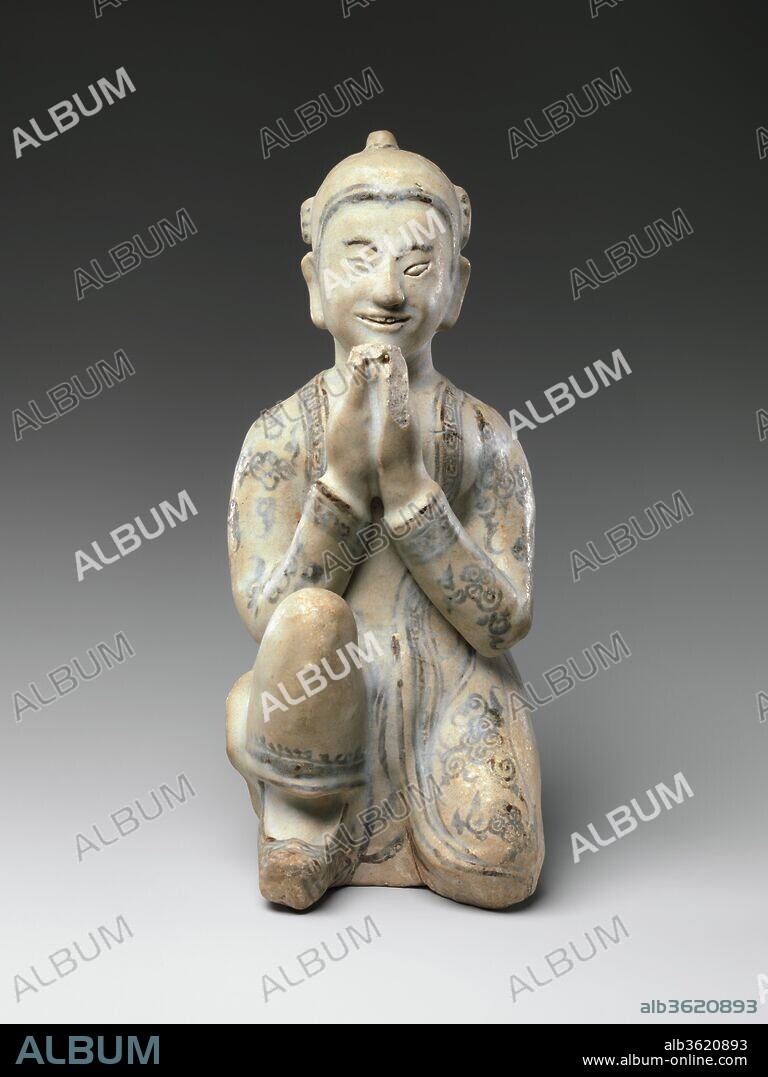 Kneeling Figure. Culture: Thailand. Dimensions: H. 9 1/2 in. (24.1 cm); W. 3 3/4 in. (9.5 cm); D. 5 in. (12.7 cm). Date: 15th-16th century.
An impressive sculptural ceramic of a male Buddhist devotee, kneeling and holding his raised hands in veneration (anjali). He is robed in a long tunic-style coat worn over a waistcloth, and he wears slippers and a pointed hat. Decorative details are highlighted in iron-painted black. This is one of the most complete figurines known and one of the most descriptive in terms of the costume of the period. It is very much a sculptural work, conceived fully in the round, fully engaging the viewer's attention. This work was intended to serve as an offering image to be placed before an altar, or Buddha image as a surrogate presence for a notable donor-devotee.