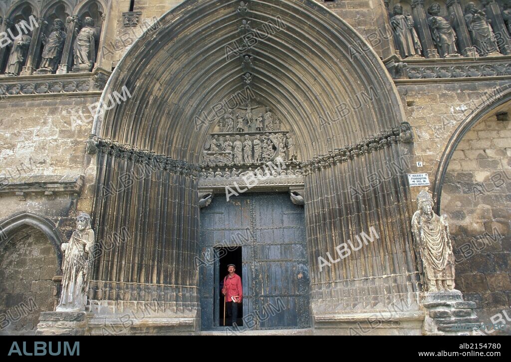 Camino of Santiago pilgrim walking out of Santo Sepulcro church in Estella.