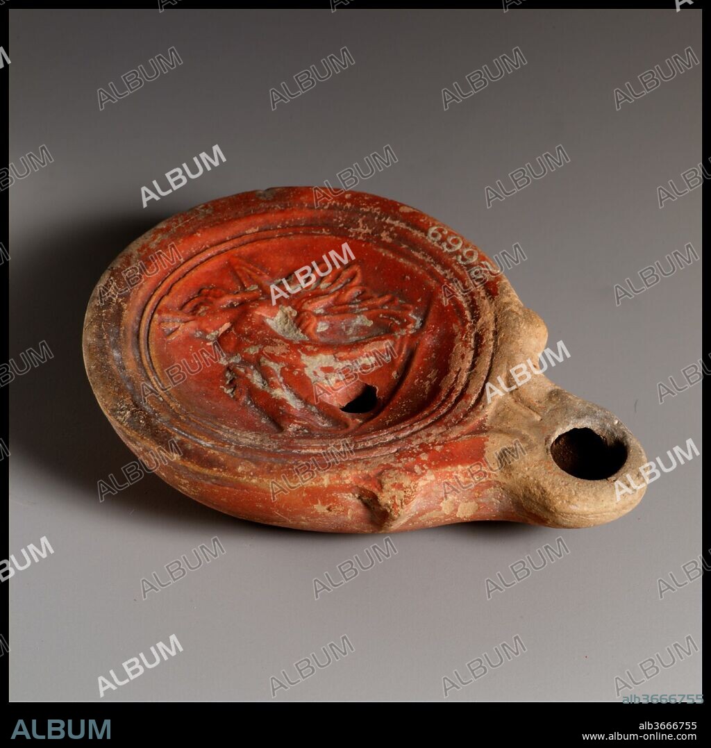 Terracotta oil lamp. Culture: Roman. Dimensions: Overall: 1 x 3 3/8 in. (2.5 x 8.6 cm). Date: ca. A.D. 40-100.
Loeschcke Type 4. Mold-made. Discus: Aktaion, standing to front, facing left, being attacked by a hound at left, and holding a spear in his left hand; all on a ground line across bottom of discus.