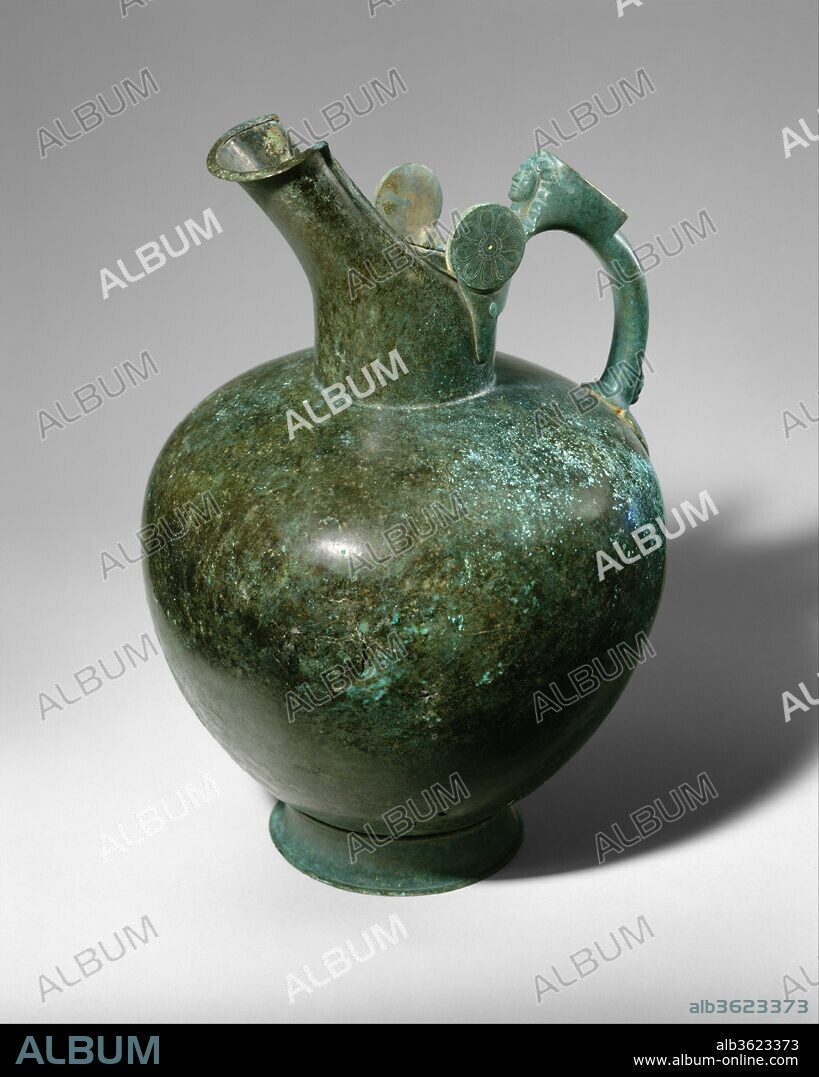 Bronze oinochoe. Culture: Greek. Dimensions: Overall: 13 9/16in. (34.4cm). Date: mid-6th century B.C..
The word "oinochoe" means "wine pourer", and the shape was a very common one throughout the Greek world. During the Archaic period, the oinochoe and the hydria (water jar) were often embellished with figural elements integrated into the handles. Here, the head of a woman appears at the top of the handle, a panther head and palmette at the bottom.  This work is distinguished not only by its fine state of preservation but also by its exceptional vigor and simplicity.