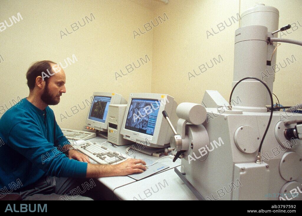 Student using Scanning Electron Microscope in college lab.