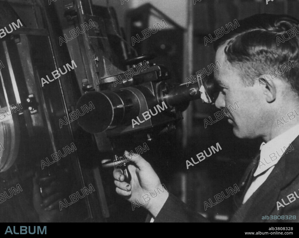 Tombaugh using blink comparator. Clyde William Tombaugh (February 4, 1906 - January 17, 1997) was an American astronomer. He became an assistant at Lowell Observatory. Lowell predicted the existence of a ninth planet, and a team was set up to find it. Tombaugh invented the blink comparator to facilitate the search. This device allowed comparison of photographs of the sky to show if any object had altered position. In 1930 he discovered the dwarf planet Pluto. He also discovered nearly 800 asteroids and hundreds of variable stars, as well as star clusters, and galaxy clusters. He is credited with the discovery of periodic comet 274P/Tombaugh-Tenagra. He was the most eminent astronomer to have reported seeing unidentified flying objects and to support the extraterrestrial hypothesis. He died in 1997 at the age of 90. One ounce of his ashes is being carried on the New Horizons space probe. The container includes the inscription: "interned herein are remains of American Clyde W. Tombaugh, discoverer of Pluto and the solar system's 'third zone'. Adelle and Muron's boy, Patricia's husband, Annette and Alden's father, astronomer, teacher, punster, and friend: Clyde W. Tombaugh (1906-1997)".