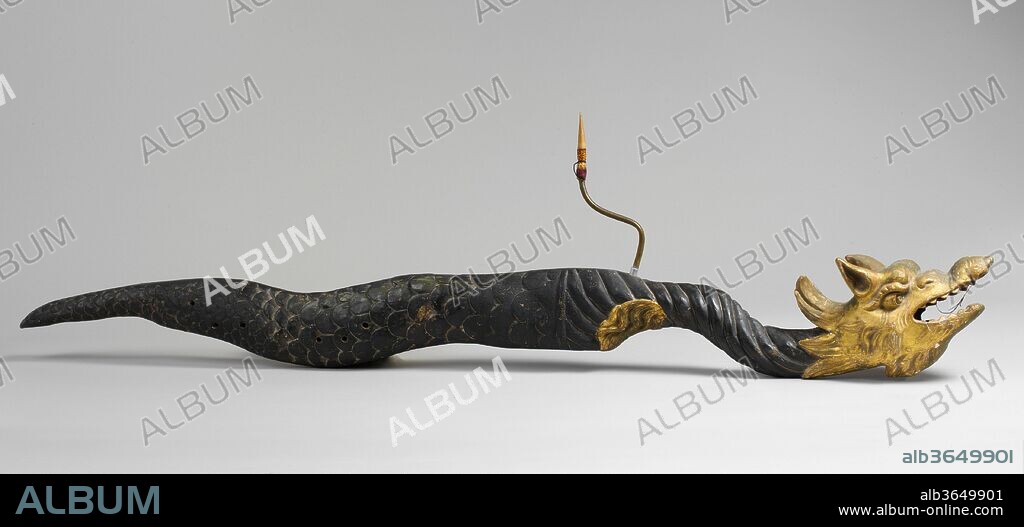 Sea Dragon. Culture: Italian. Dimensions: Height: 54 1/2 in. (138.4 cm)
Width: 8 in. (20.3 cm)
Depth: 3 1/2 in. (8.9 cm). Date: 17th century.
This and a similar dragon in The Cincinnati Art Museum are the only known instruments of this kind to survive. Used as a stage prop, it probably appeared in masquerades and theatrical scenes depicting the underworld. The instruments were capable of producing sounds and noises that supported onstage dramaturgical actions both visually and aurally. Made from two joined hollowed out lengths of wood, the dragon was then sculpted, painted a dark green and gilded on its head and fins. During the 19th century the body was partially re-painted black. The original mouthpiece and bocal are now missing.