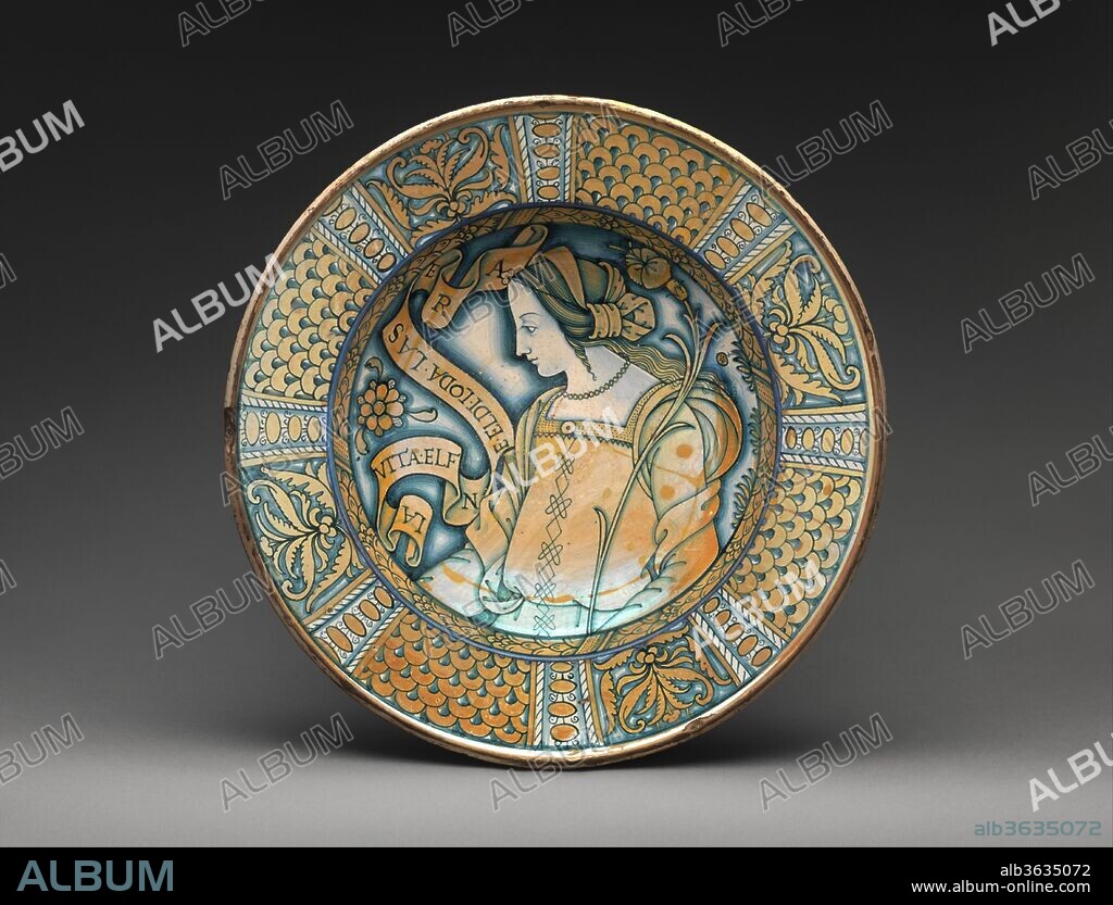 Dish with profile of a woman with Petrarchan verse. Culture: Italian, Deruta. Dimensions: Overall (confirmed): 3 1/2 × 15 7/8 in. (8.9 × 40.3 cm). Date: ca. 1510-30.
The Umbrian town of Deruta was an important center of maiolica production and was particularly famous for its display plates--especially those bearing images of lovely women. Here, confident lines describe a graceful feminine profile. Dishes such as this example functioned as a circular picture, with the patterned rim enclosing and enhancing the central image, not unlike a framed panel painting.