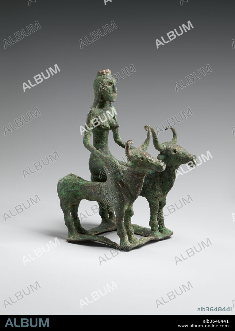 Woman Riding Two Brahman Bulls. Culture: India (Kausambi). Dimensions: H. 5 1/2 in. (14 cm); W. 3 1/2 in. (8.9 cm); D. 4 1/2 in. (11.4 cm). Date: 2000-1750 B.C..
This remarkable object is the oldest bronze object in the Museum's Indian collections, and is a rare survivor of the early bronze culture associated with the late Harappan civilization shared across northern India and the Indus Valley (Pakistan) in the second millennium B.C. 
Two humped ('Brahman') bulls support a platform on which is a woman is kneeling. Her hands rest on the bulls' humps. The ensemble is on a rectangular platform, which has been separately cast. The woman has a slender physique, pointed breasts, and hair that extends to her shoulders. She wears a small circular crown-like fitting atop her head, has deep eye sockets and an incised mouth. The symmetry of the female figure is mirrored in standing female clay figurines from this period and later.