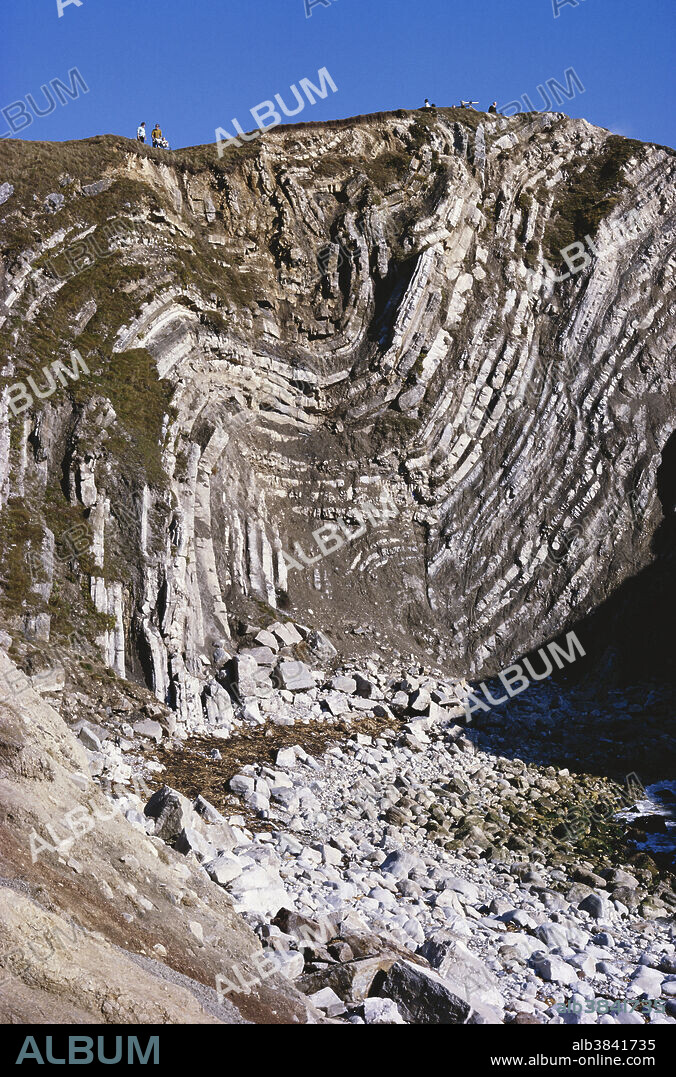 Folded Portland limestone at Stair Hole near Lulworth, Dorset, England. The layers of Jurassic rock, originally deposited in horizontal beds, have been folded as a result of the collision between the African and European crustal plates.