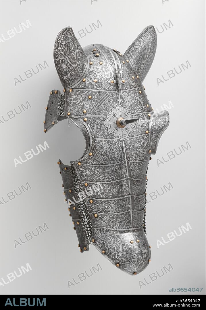 Shaffron (Horse's Head Defense). Culture: Italian, probably Brescia. Dimensions: H. 24 7/8 in. (63.2 cm); W. 12 1/4 in. (31.1 cm); D. 9 in. (22.9 cm); Wt. 4 lb. 11 oz. (2132 g). Date: ca. 1560-70.
This shaffron is of an unusual construction that appears to be consciously imitative of Turkish armor of the period, which was made of multiple small plates of iron attached by mail to form a very flexible defense. The etched decoration, however, is typically Italian in its use of trophies and grotesques inspired by classical prototypes. The style of etching and the overall covering of the armor's surface with ornament are characteristic of armors made in Brescia, the principal arms manufacturing center in the Veneto. Armors constructed in emulation of Turkish examples reflect a taste for the exotic that had existed in Venice for centuries as a result of the republic's regular encounter, through trade and warfare, with the Middle East.