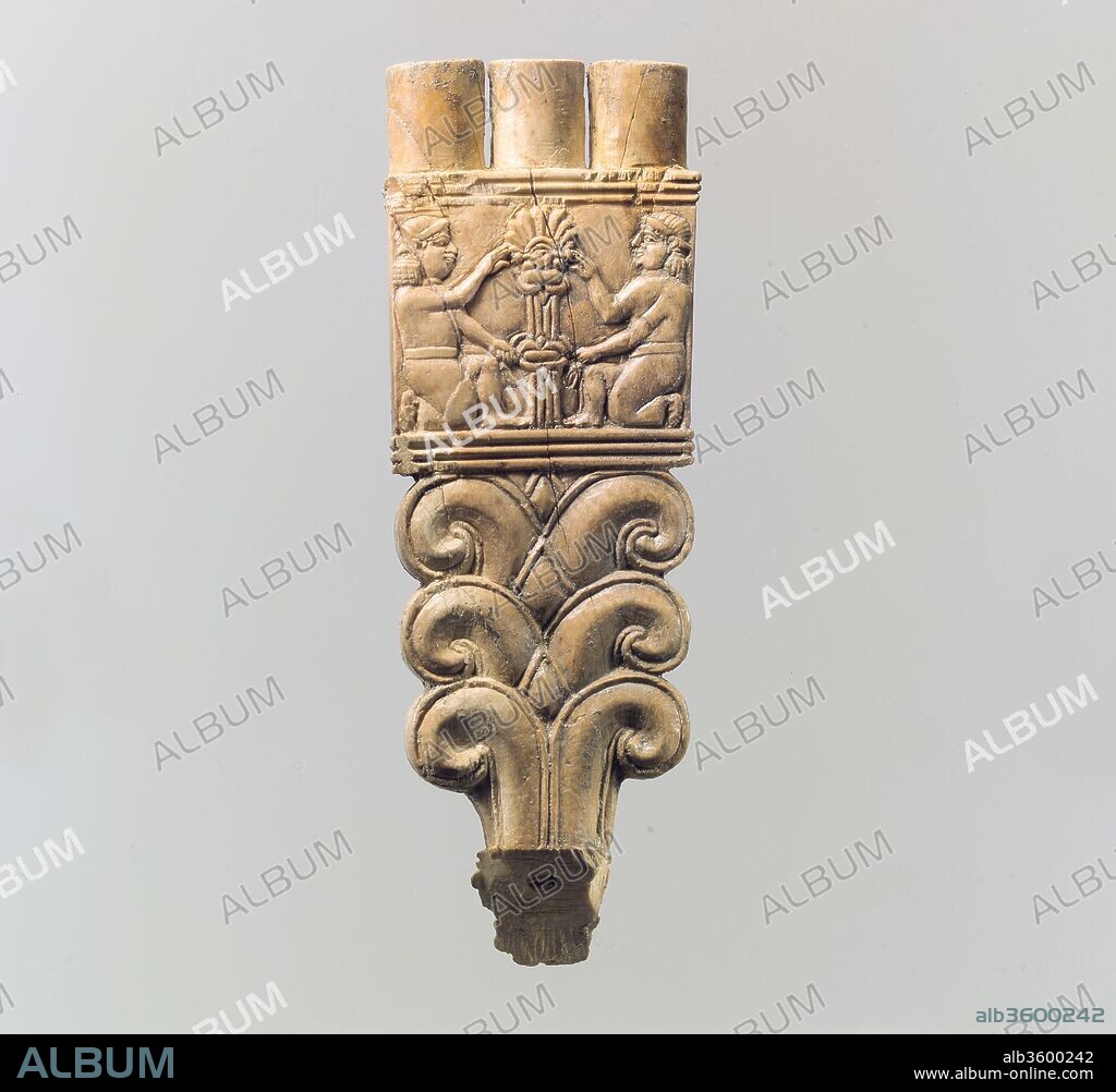 Handle of a flywhisk or fan. Culture: Assyrian. Dimensions: H. 4 x W. 1 3/8 in. (10.2 x 3.5 cm). Date: ca. 8th-7th century BC.
Both sides of this handle are decorated with two figures kneeling before a stylized tree, an image perhaps related to similar ritual scenes on reliefs from Assyrian palaces. Such Assyrian style ivories are usually carved using an incised technique, but this is a rare example carved in relief. As the figures are beardless, they may be eunuchs or, more likely, women. They are shown plucking what may be pomegranates, a fruit whose many seeds led it to be associated with fertility. Handles in a similar form are shown on the reliefs of Ashurbanipal, an Assyrian king who ruled during the seventh century B.C., with long feathers inserted in the hollow cylinders at the top, suggesting how this handle may have originally looked. Based on the scene depicted on the handle and the location where it was excavated, within the private residential areas of the palace, it has been suggested that the fan was used by Assyrian royal women.
Built by the Assyrian king Ashurnasirpal II, the palaces and storerooms of Nimrud housed thousands of pieces of carved ivory. Most of the ivories served as furniture inlays or small precious objects such as boxes. While some of them were carved in the same style as the large Assyrian reliefs lining the walls of the Northwest Palace, the majority of the ivories display images and styles related to the arts of North Syria and the Phoenician city-states. Phoenician style ivories are distinguished by their use of imagery related to Egyptian art, such as sphinxes and figures wearing pharaonic crowns, and the use of elaborate carving techniques such as openwork and colored glass inlay. North Syrian style ivories tend to depict stockier figures in more dynamic compositions, carved as solid plaques with fewer added decorative elements. However, some pieces do not fit easily into any of these three styles. Most of the ivories were probably collected by the Assyrian kings as tribute from vassal states, and as booty from conquered enemies, while some may have been manufactured in workshops at Nimrud. The ivory tusks that provided the raw material for these objects were almost certainly from African elephants, imported from lands south of Egypt, although elephants did inhabit several river valleys in Syria until they were hunted to extinction by the end of the eighth century B.C.