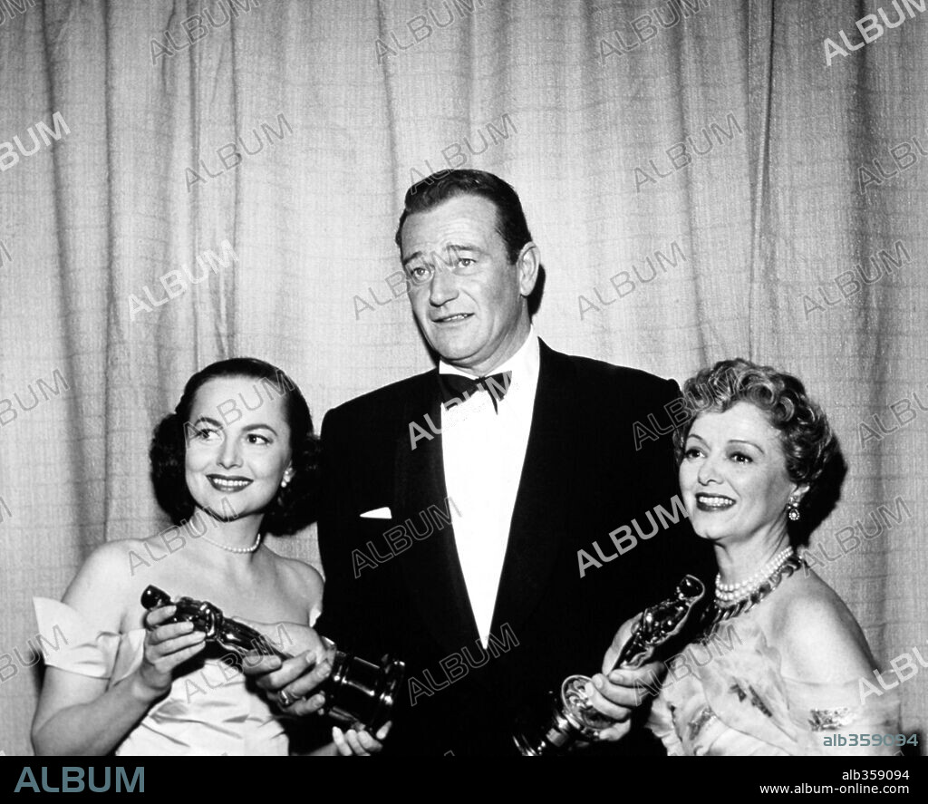 JANET GAYNOR JOHN WAYNE and OLIVIA DE HAVILLAND. The 25th Academy Awards 1952. Olivia de Havilland with John Wayne who picks up on behalf of Gary Cooper the best acto Album alb359094